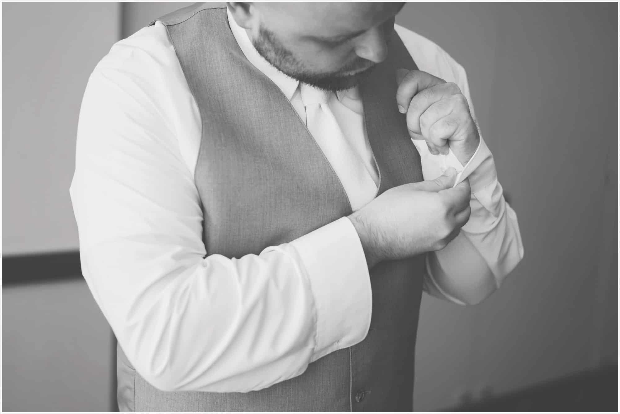groom putting cufflinks on