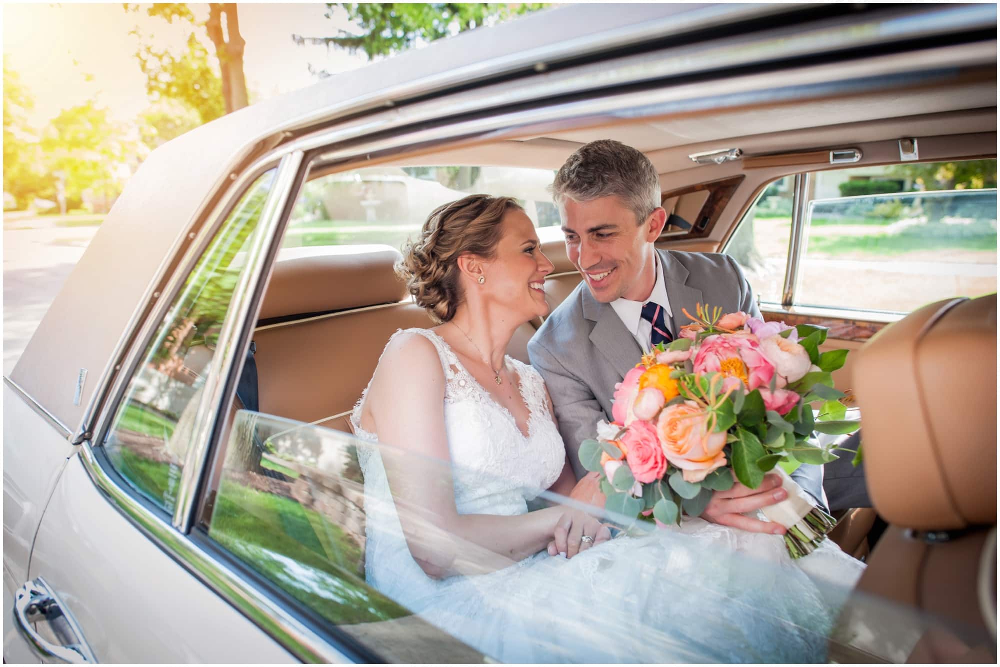 bride and groom looking at eachother in the back of a vintage car on wedding day from the window frame on the way to Hyatt McDonalds Lodge Oak Brook Wedding Photographer