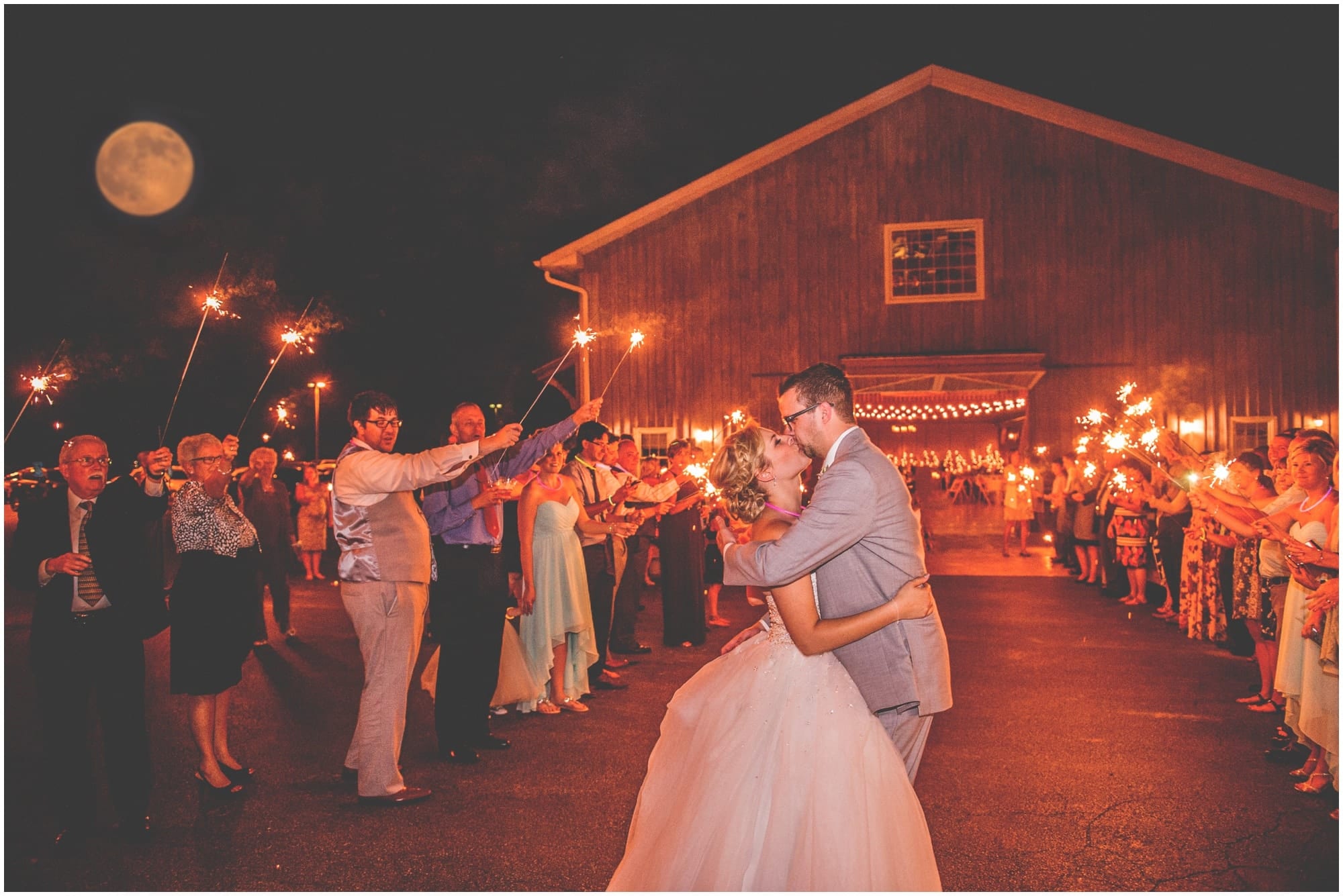 County Line Orchard Wedding Photographer bride and groom sparkler exit and kiss with full moon 